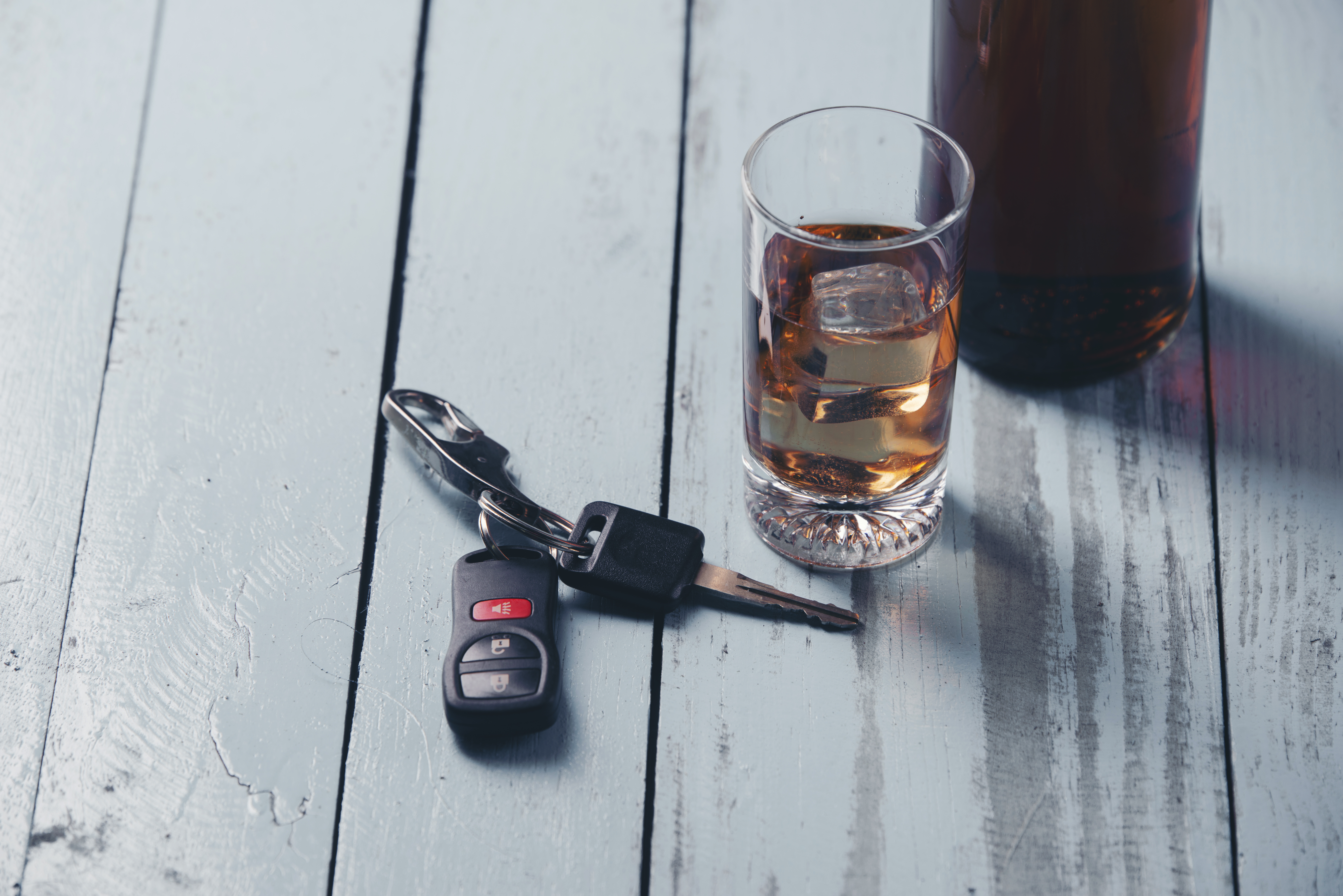 Car keys beside glass of alcohol